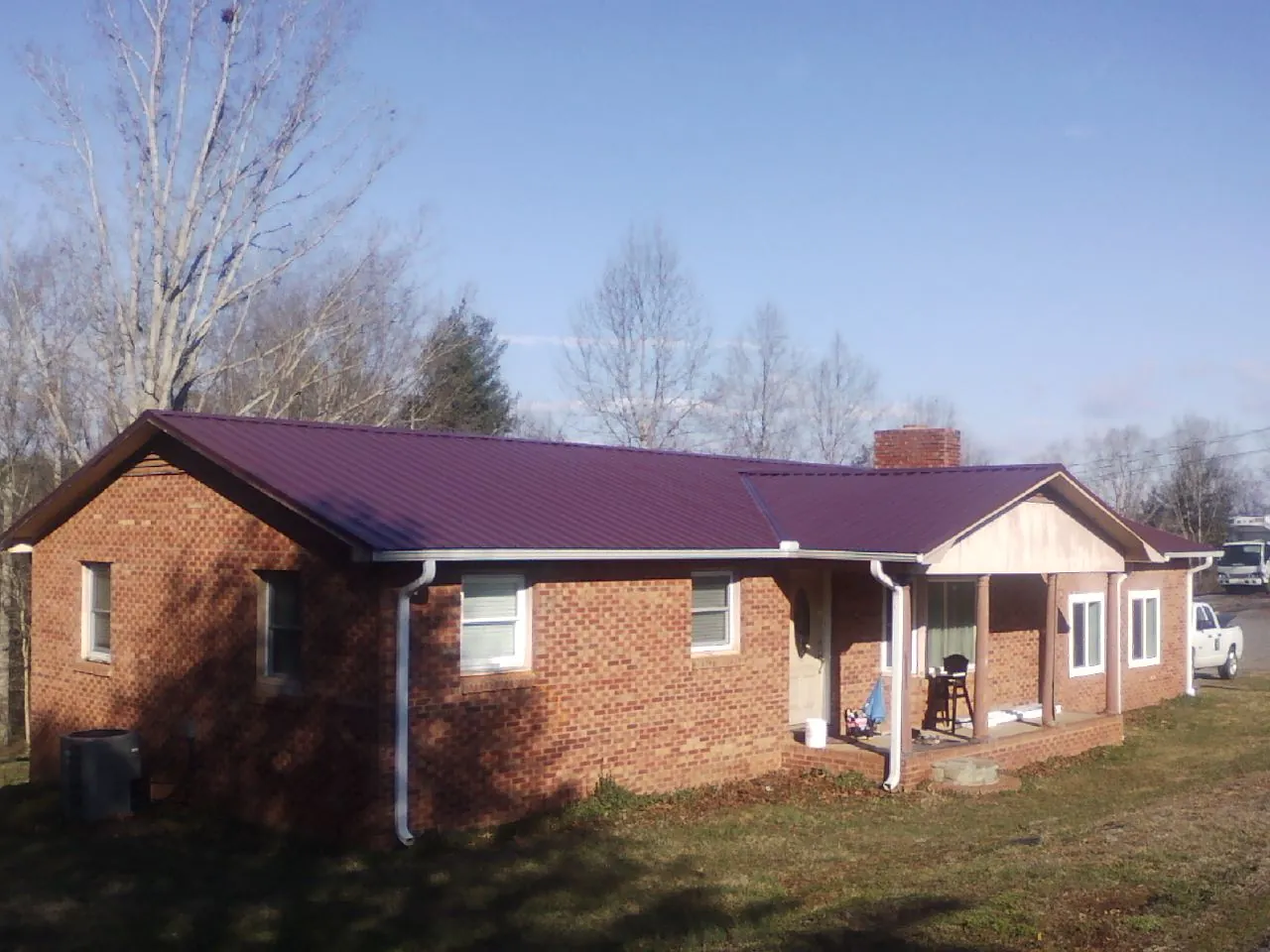 Burgundy metal roof on a brick ranch home with a new addition in Cape Charles