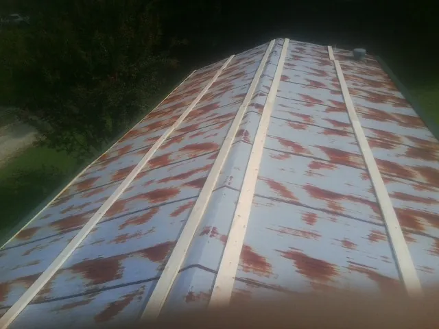 Rusted metal roof panels with new wood purlins before replacement — Storm Damage Roof Repair in Cape Charles by Roofing Brothers