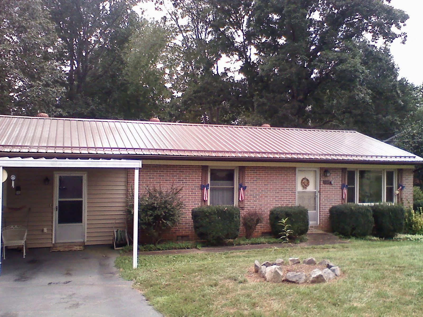 Bronze metal roof and carport on a brick ranch home — Roof Repair work by our crew in Cape Charles