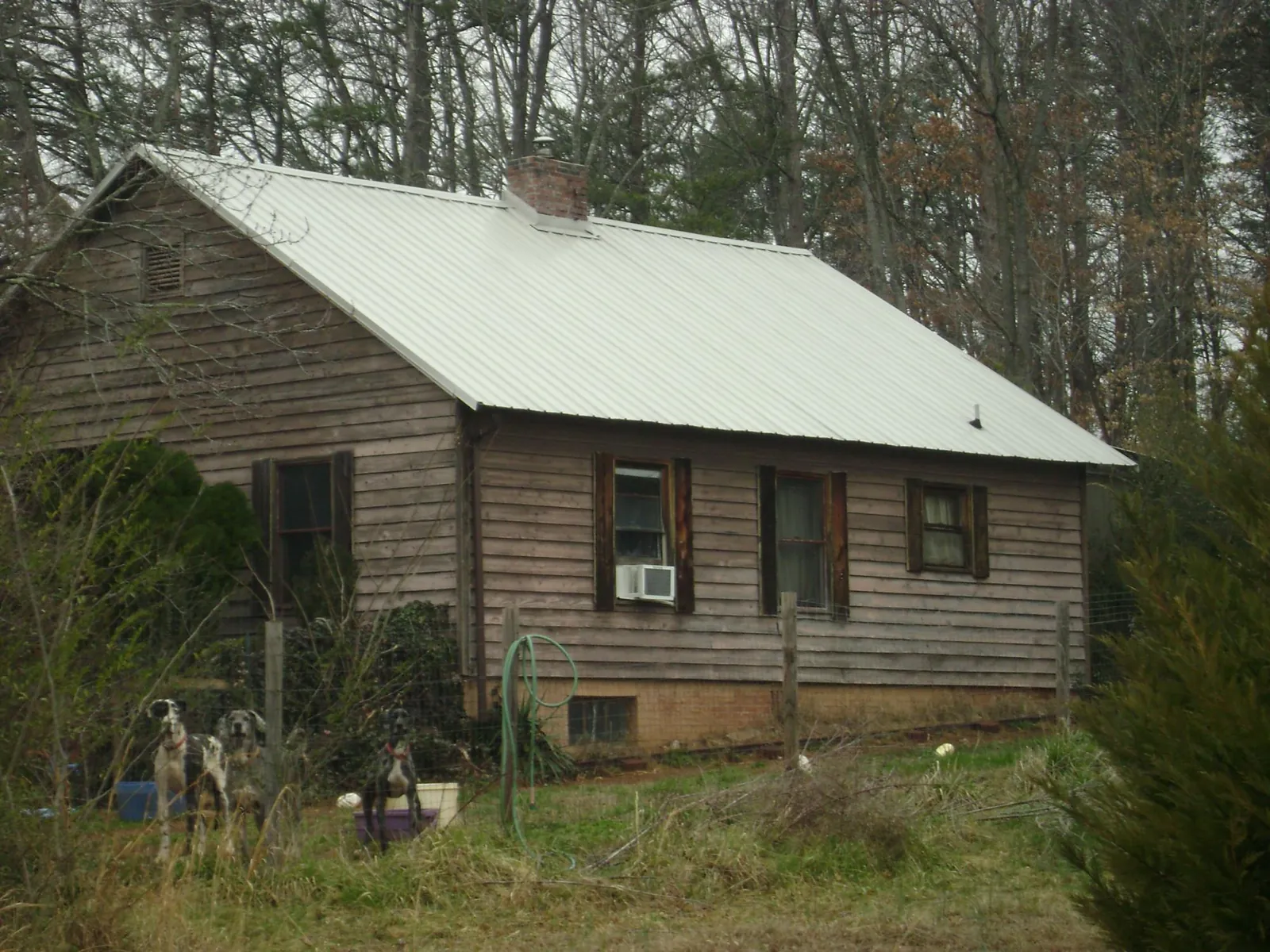White metal roof on an old wood sided farmhouse, from a Metal Roof Installation job in Cape Charles